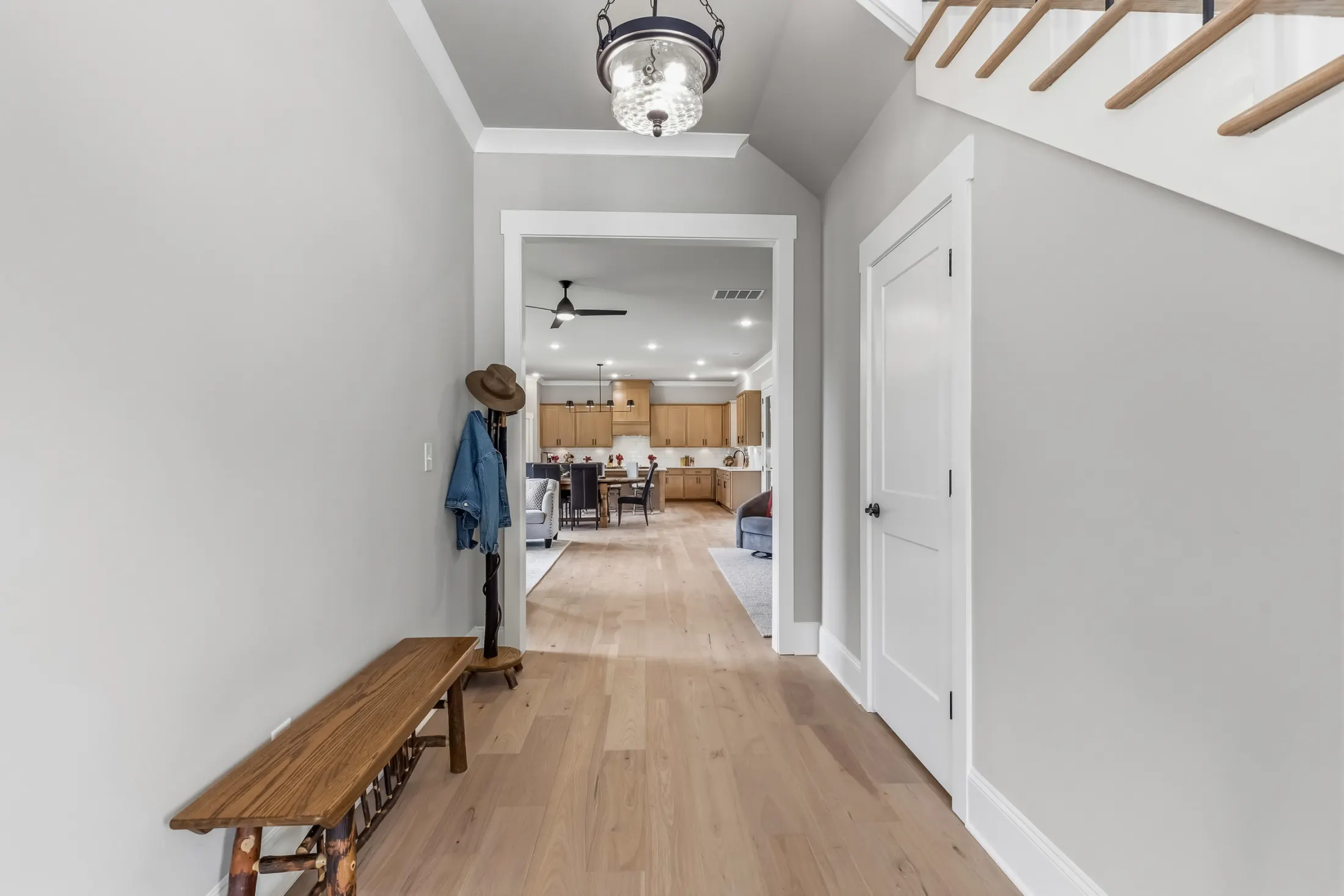Entry hallway with a bench and coat stand looking toward the kitchen