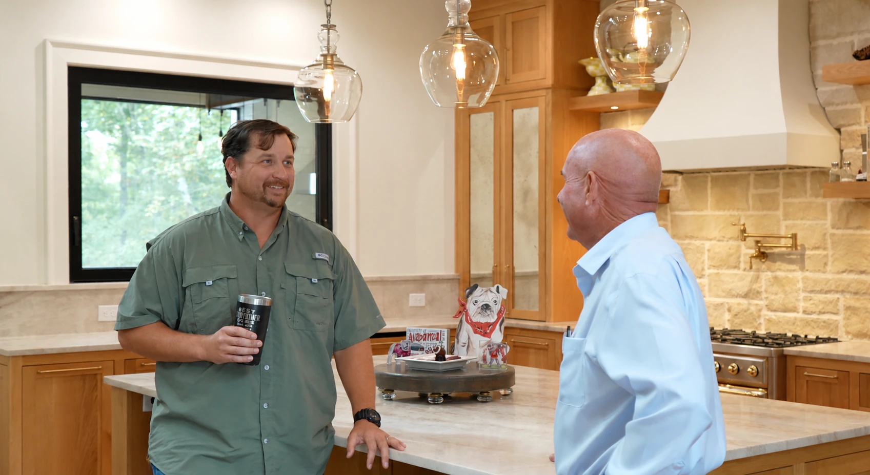 Wyndell Thomas talking with a client in a kitchen with glass pendant lights
