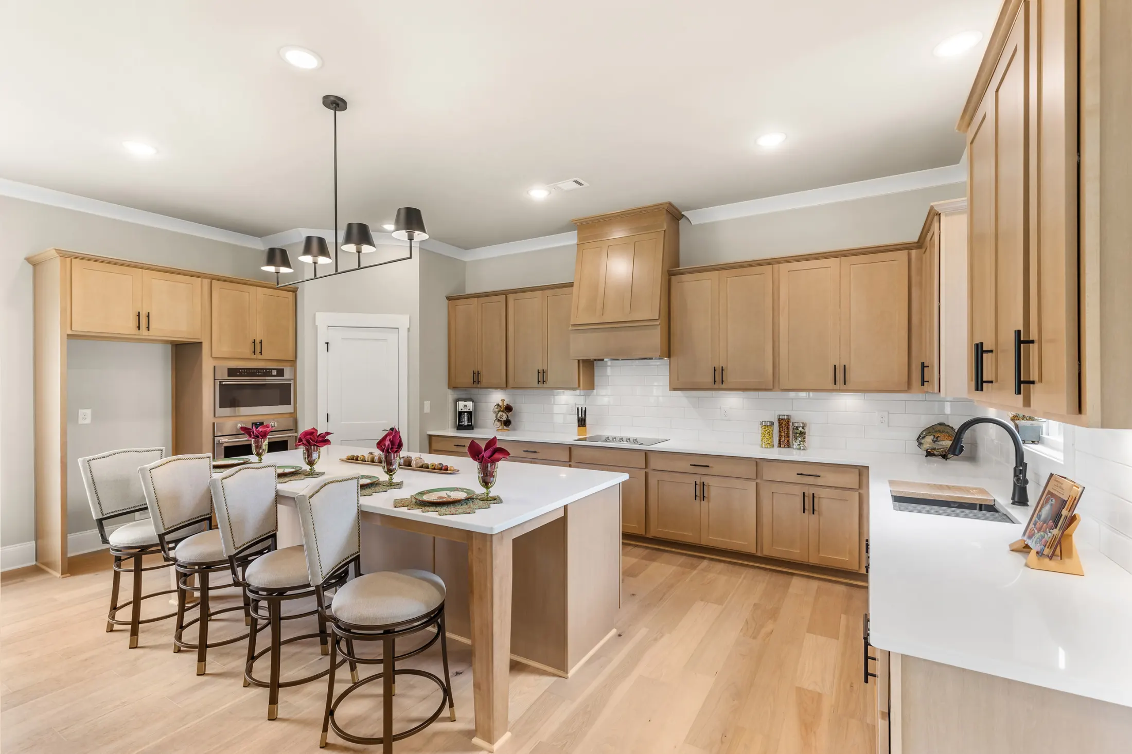 Kitchen with wood shaker cabinets, a white quartz island and bar stools